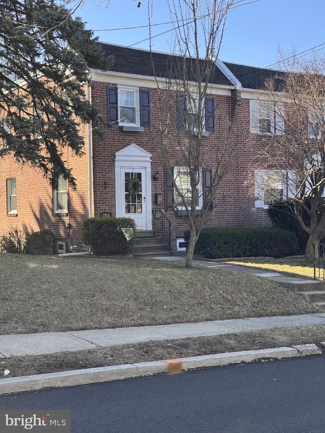 view of front of property with brick siding and a front lawn