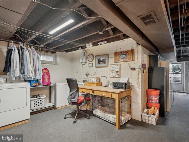 basement with visible vents, washer / dryer, and refrigerator