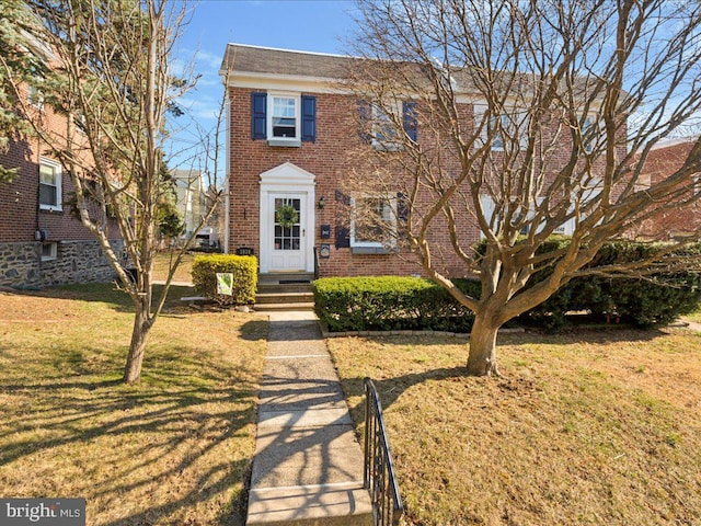 view of front of home featuring brick siding and a front yard