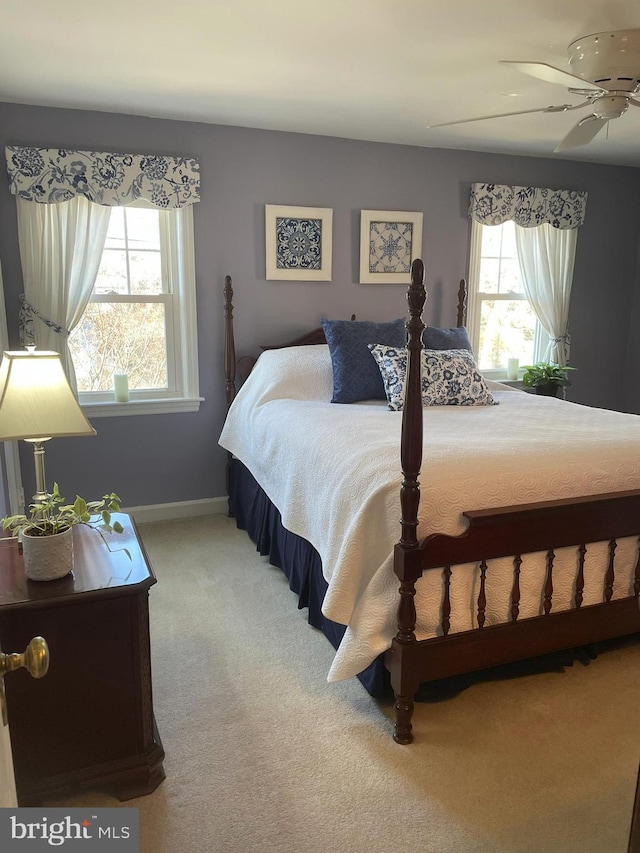 bedroom featuring multiple windows, baseboards, carpet, and ceiling fan