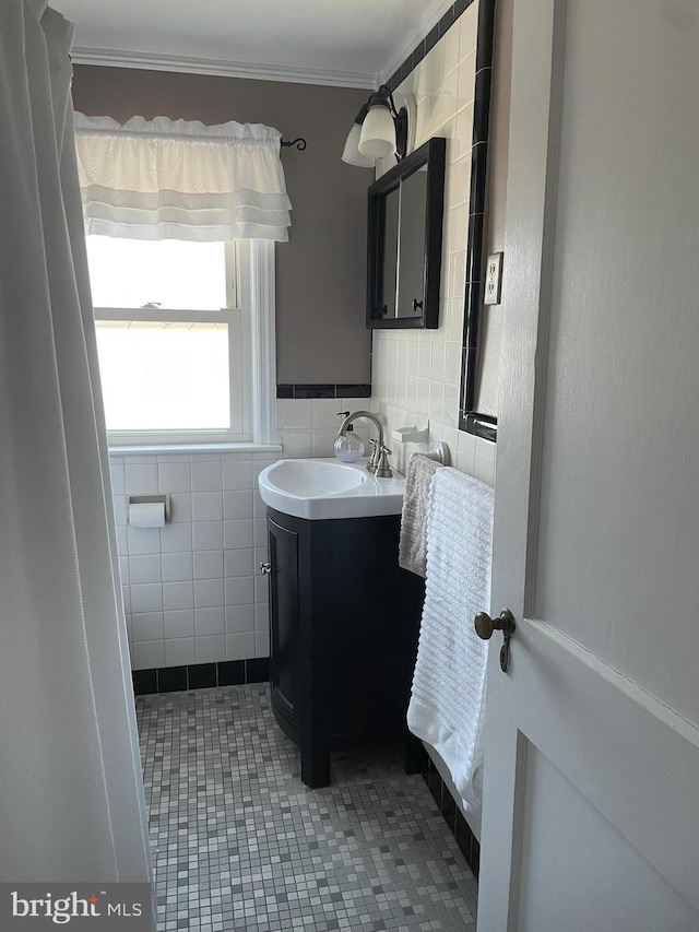 bathroom featuring vanity, tile walls, tile patterned flooring, and ornamental molding