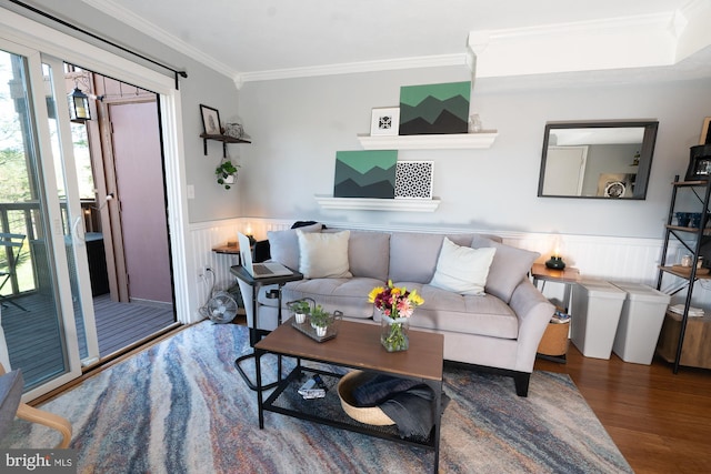 living room featuring a wainscoted wall, wood finished floors, and crown molding