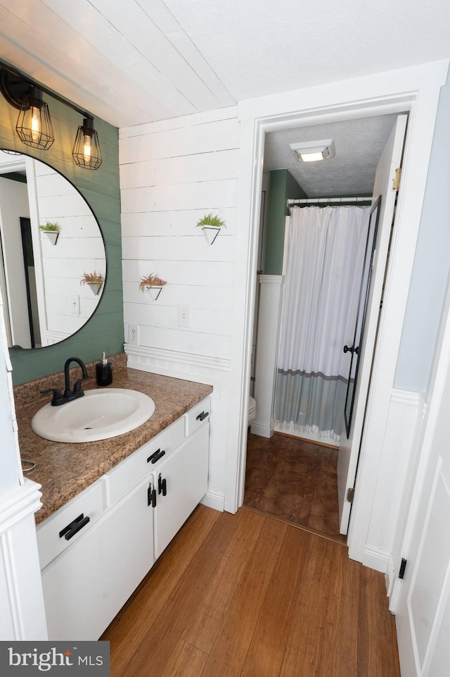 bathroom featuring visible vents, toilet, a shower with curtain, wood finished floors, and vanity