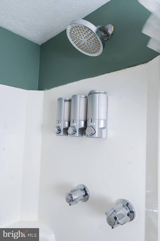 interior details with a textured ceiling and walk in shower