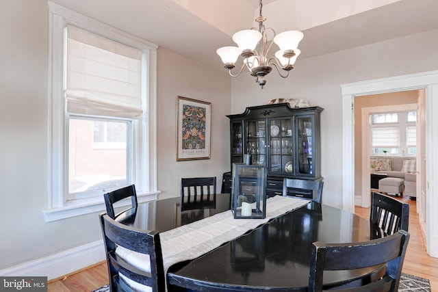 dining room featuring baseboards, an inviting chandelier, and light wood-style flooring