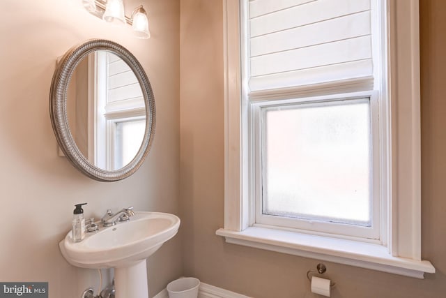 bathroom featuring baseboards and a sink