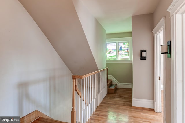 hallway featuring stairway, baseboards, and light wood-style floors