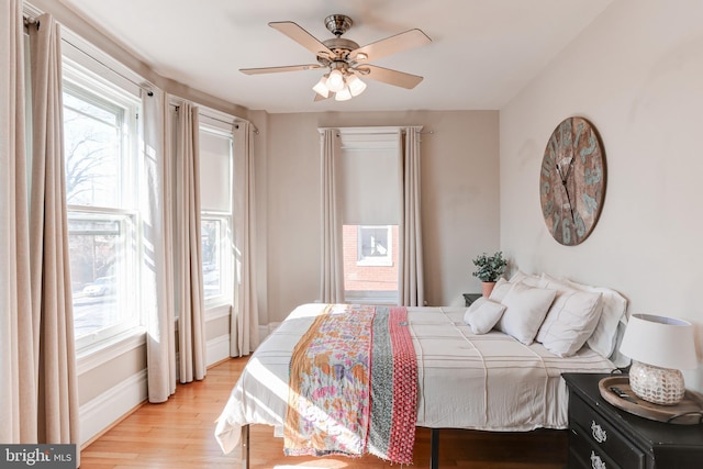 bedroom with baseboards, a ceiling fan, and light wood finished floors