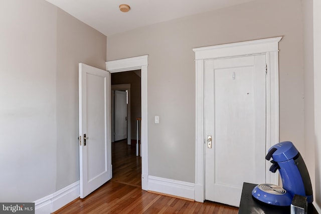 bedroom with wood finished floors and baseboards