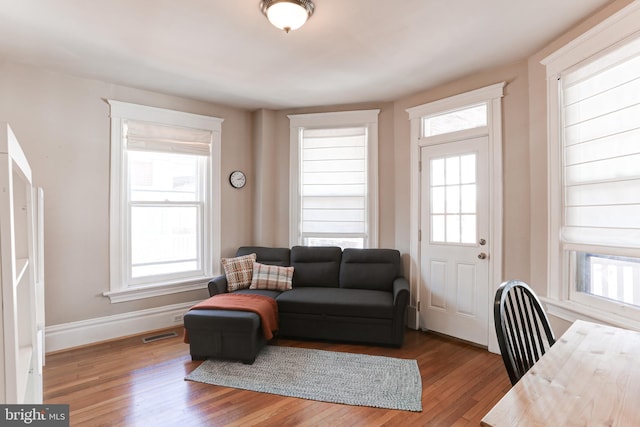 living room with visible vents, baseboards, and wood finished floors