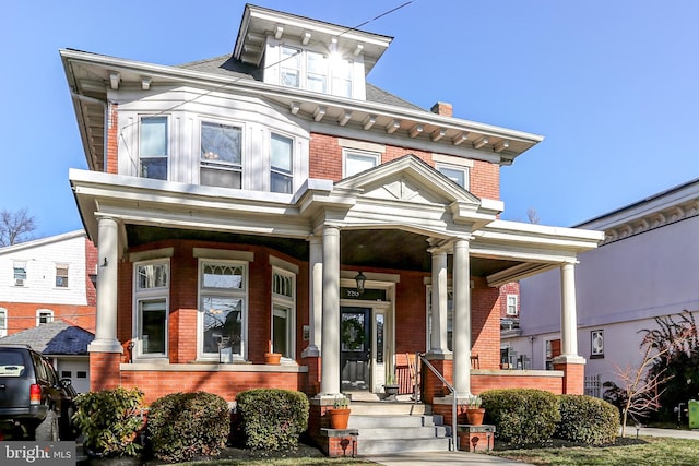 view of front of house with brick siding and covered porch