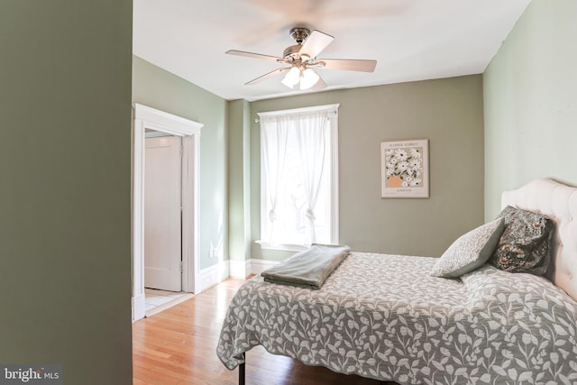 bedroom with wood finished floors, baseboards, and ceiling fan