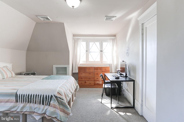 bedroom featuring visible vents, lofted ceiling, and carpet