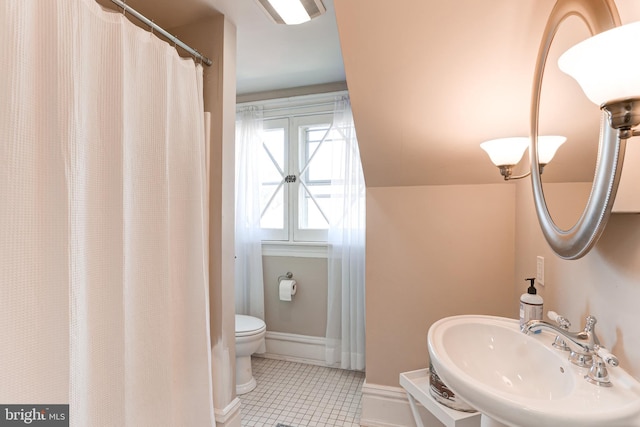 full bathroom featuring baseboards, toilet, vaulted ceiling, tile patterned floors, and a sink