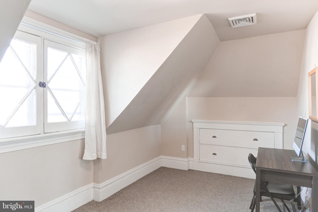 additional living space with vaulted ceiling, light colored carpet, visible vents, and baseboards