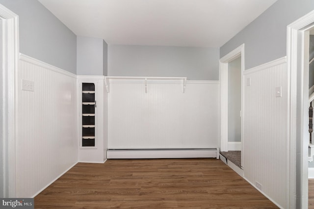 walk in closet featuring a baseboard heating unit and wood finished floors