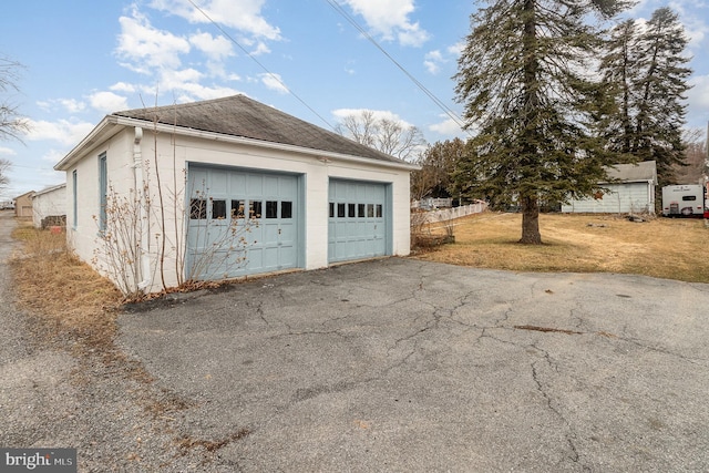 detached garage featuring fence