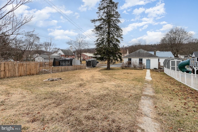 view of yard with an outbuilding, a storage shed, and fence