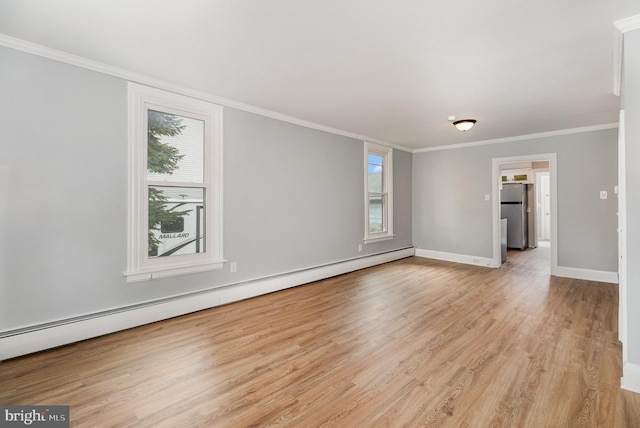 empty room featuring light wood finished floors, plenty of natural light, crown molding, and a baseboard radiator