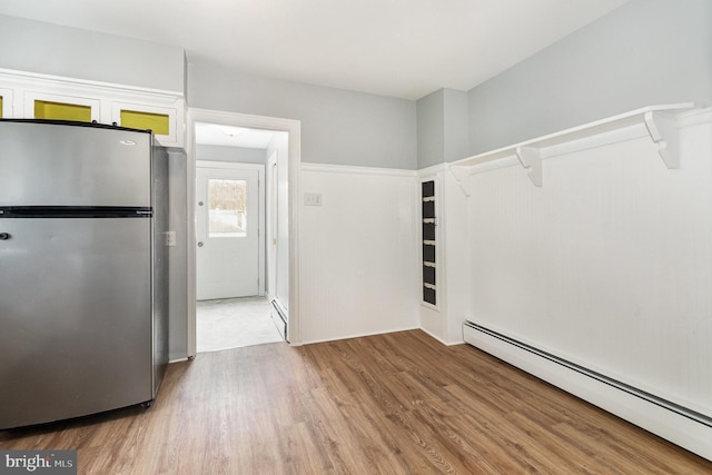 kitchen featuring a baseboard radiator, wood finished floors, a baseboard heating unit, and freestanding refrigerator