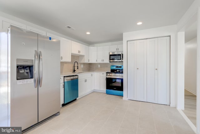 kitchen featuring visible vents, a sink, tasteful backsplash, stainless steel appliances, and light countertops