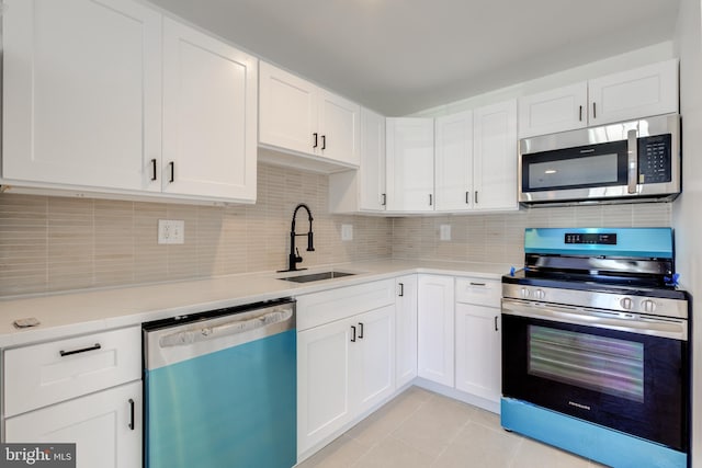 kitchen with decorative backsplash, light countertops, appliances with stainless steel finishes, and a sink