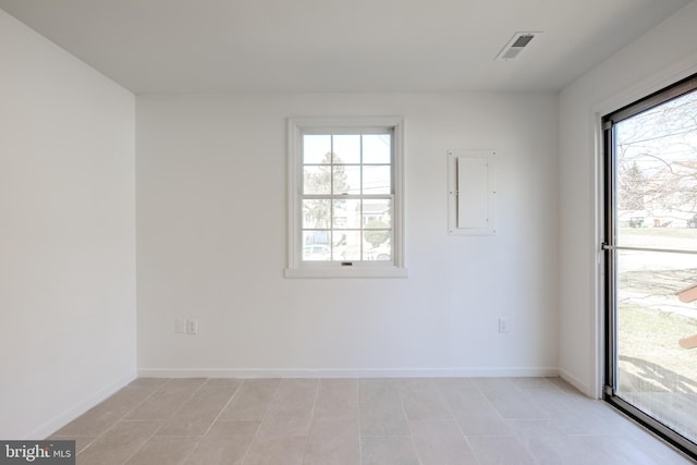 empty room featuring electric panel, baseboards, and visible vents