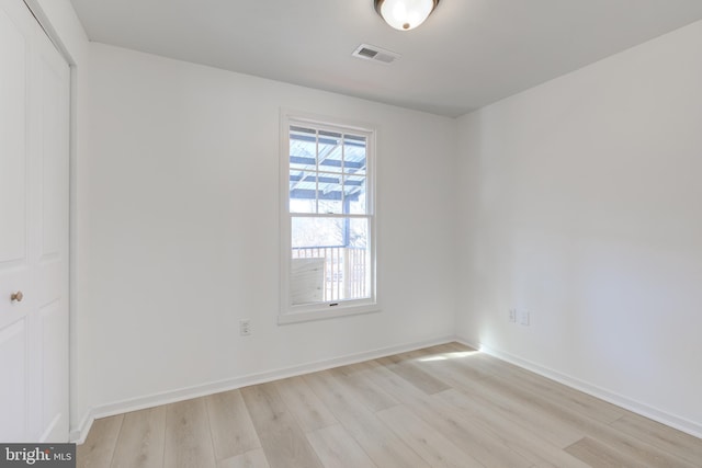 unfurnished room featuring baseboards, visible vents, and light wood finished floors