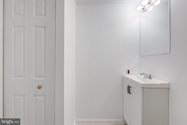 bathroom featuring a closet, vanity, and baseboards