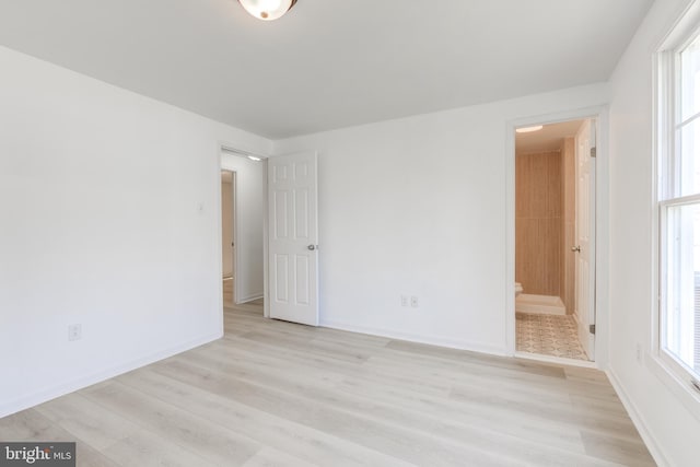 empty room with baseboards and light wood finished floors