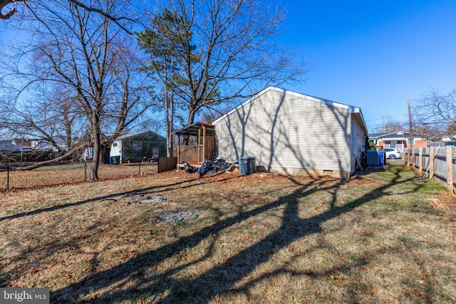 view of outbuilding with central air condition unit and fence