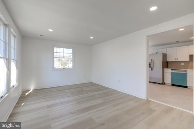 unfurnished living room featuring recessed lighting, light wood-type flooring, and baseboards