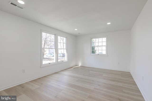 empty room featuring recessed lighting, visible vents, light wood finished floors, and baseboards