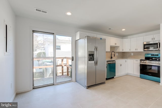 kitchen with visible vents, backsplash, light countertops, stainless steel appliances, and a sink