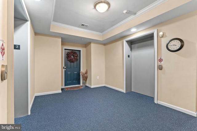 entrance foyer with visible vents, ornamental molding, dark carpet, elevator, and a raised ceiling