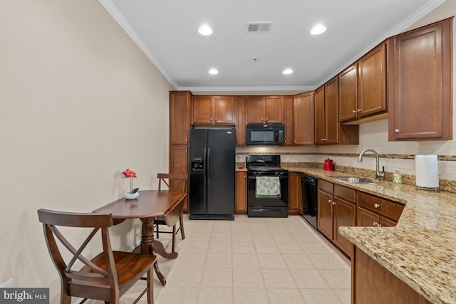 kitchen featuring visible vents, black appliances, a sink, crown molding, and light stone countertops