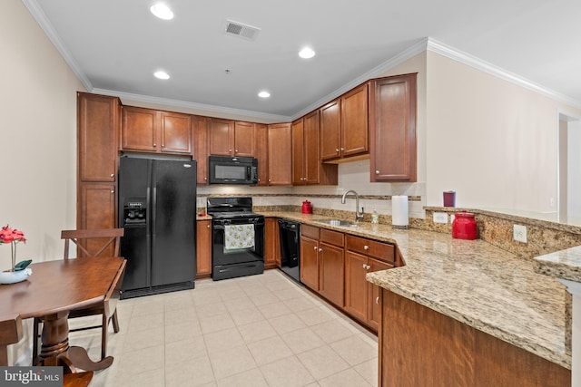 kitchen featuring black appliances, crown molding, and a sink