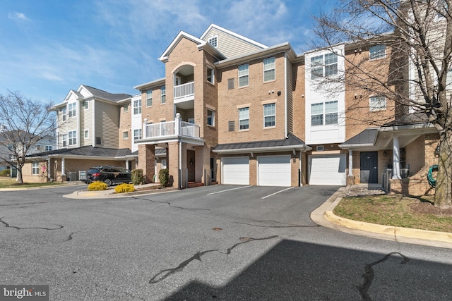 view of building exterior with an attached garage, a residential view, and driveway