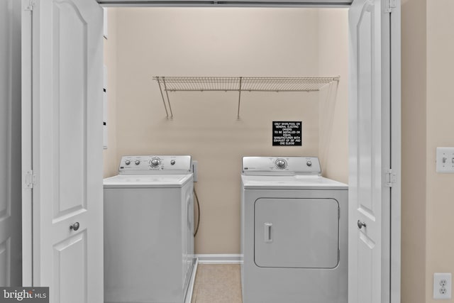 laundry room with laundry area, baseboards, and separate washer and dryer