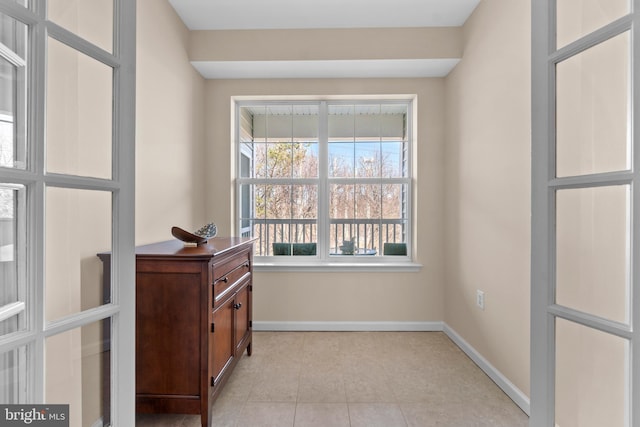 interior space with light tile patterned floors and baseboards