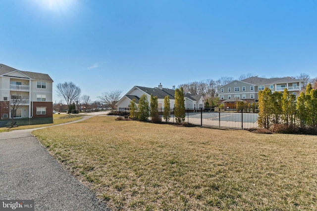 view of community with fence, a residential view, and a lawn