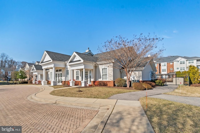 view of front of home with brick siding, a residential view, a chimney, and a gate