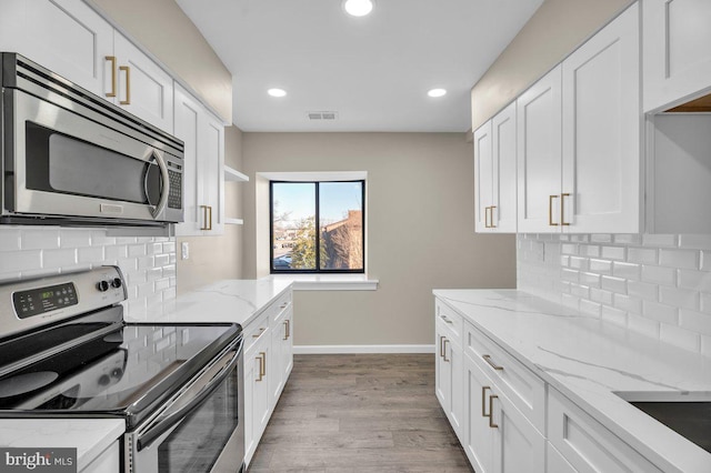 kitchen with stainless steel appliances, visible vents, and white cabinets