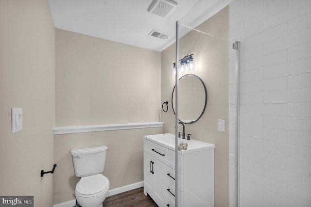 bathroom featuring visible vents, toilet, vanity, and baseboards