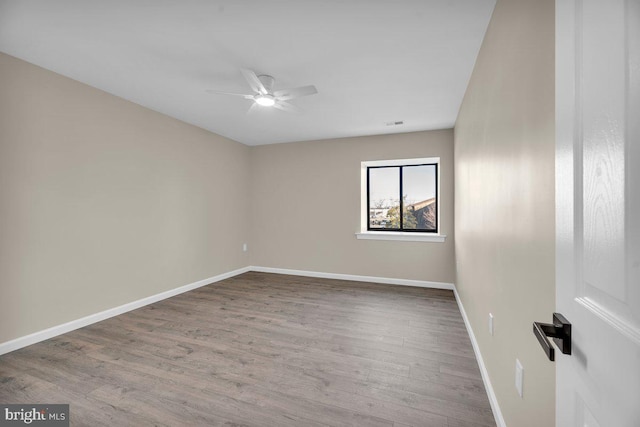 unfurnished room with ceiling fan, baseboards, and wood finished floors