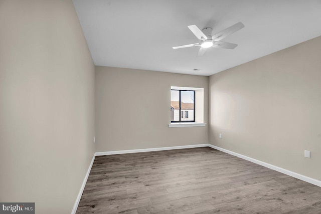 empty room featuring wood finished floors, baseboards, and ceiling fan