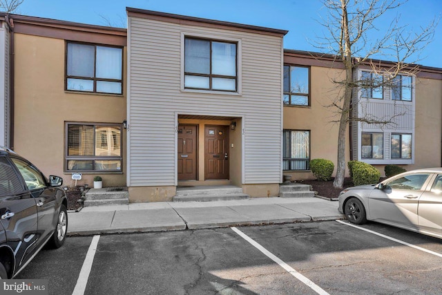 view of property featuring stucco siding and uncovered parking