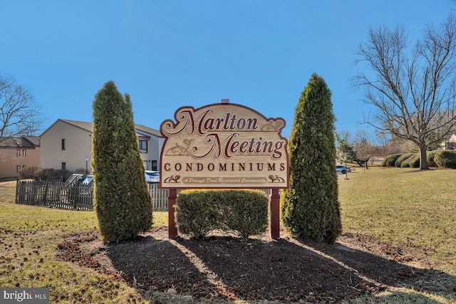 community / neighborhood sign featuring a lawn and fence