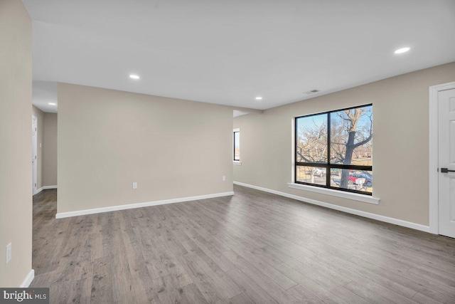 unfurnished room with visible vents, recessed lighting, wood finished floors, and baseboards