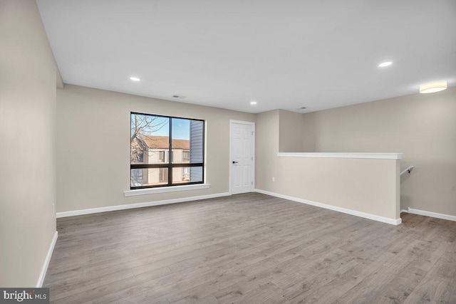 unfurnished room featuring recessed lighting, baseboards, and wood finished floors